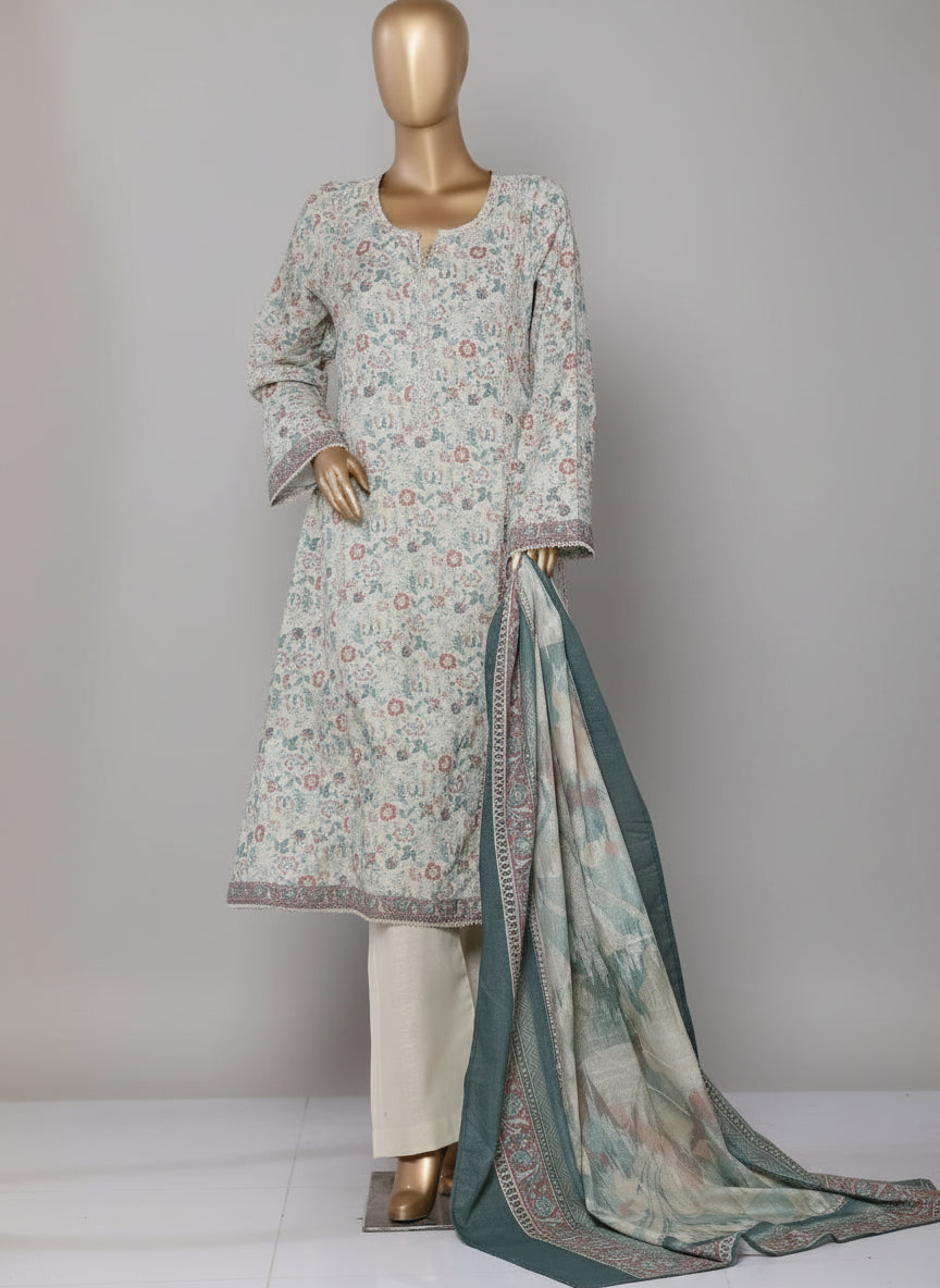 Woman wearing a floral dress with a blue dupatta in a room with curtains and a chair.