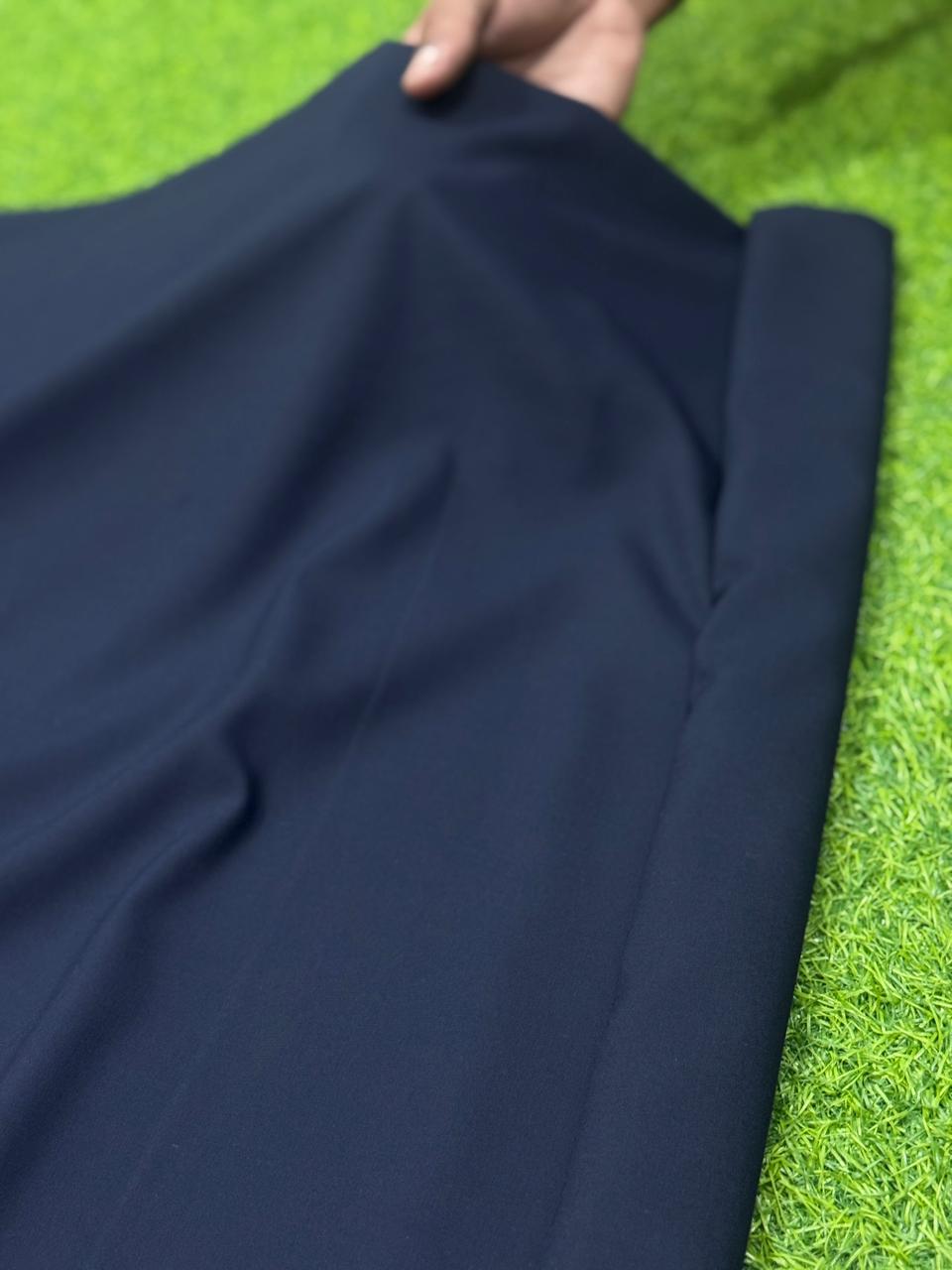 Navy blue fabric held by a hand on a grass background