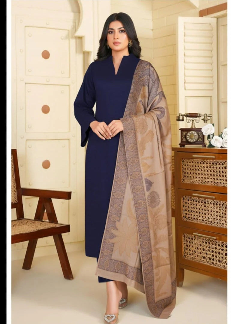 Woman in a blue dress with a brown patterned scarf in a room with wooden furniture.