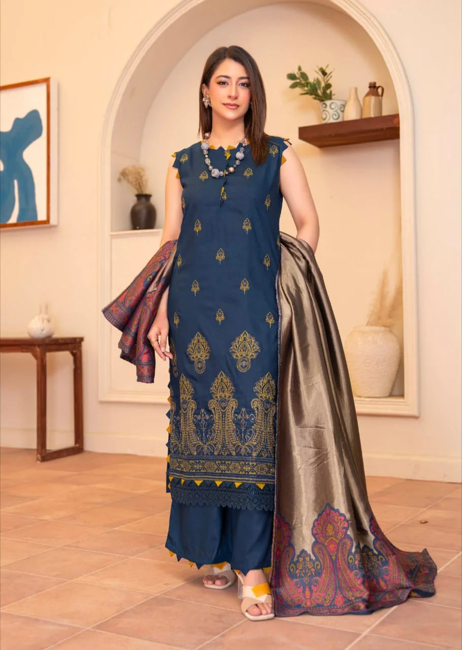 Woman wearing a blue embroidered outfit with a saree in a decorated room.