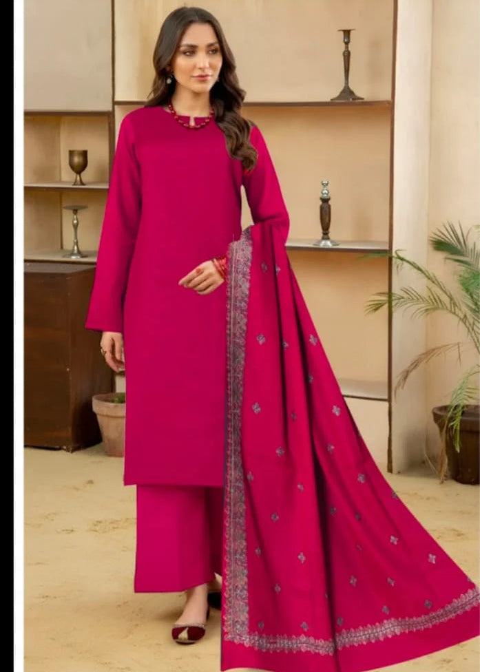 Woman wearing a pink traditional outfit with a matching dupatta in a room setting.