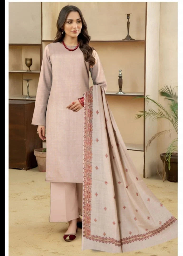 Woman wearing a light pink traditional outfit with a matching dupatta in a room setting.
