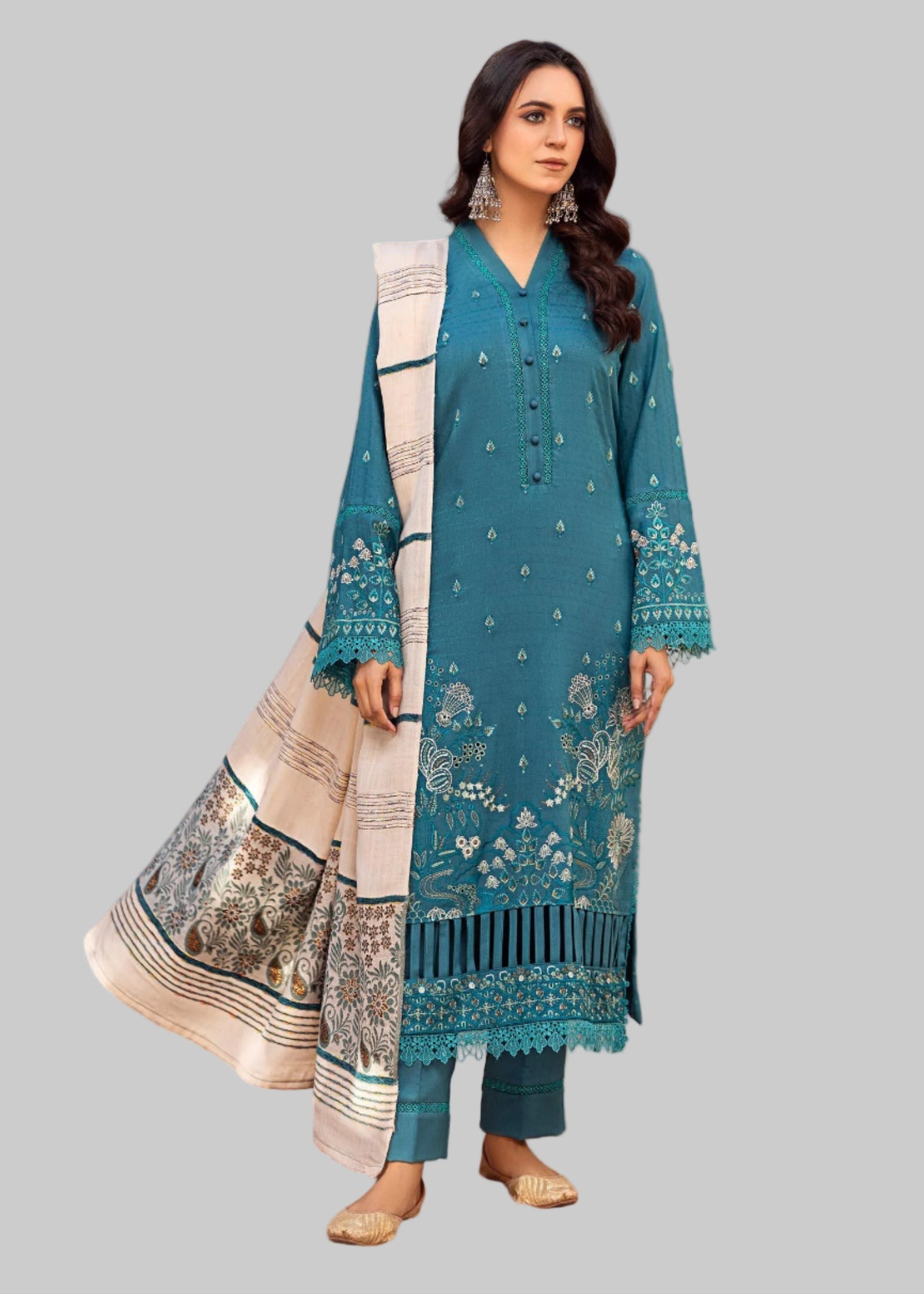 Woman in a blue traditional outfit with a white dupatta in a decorated room.