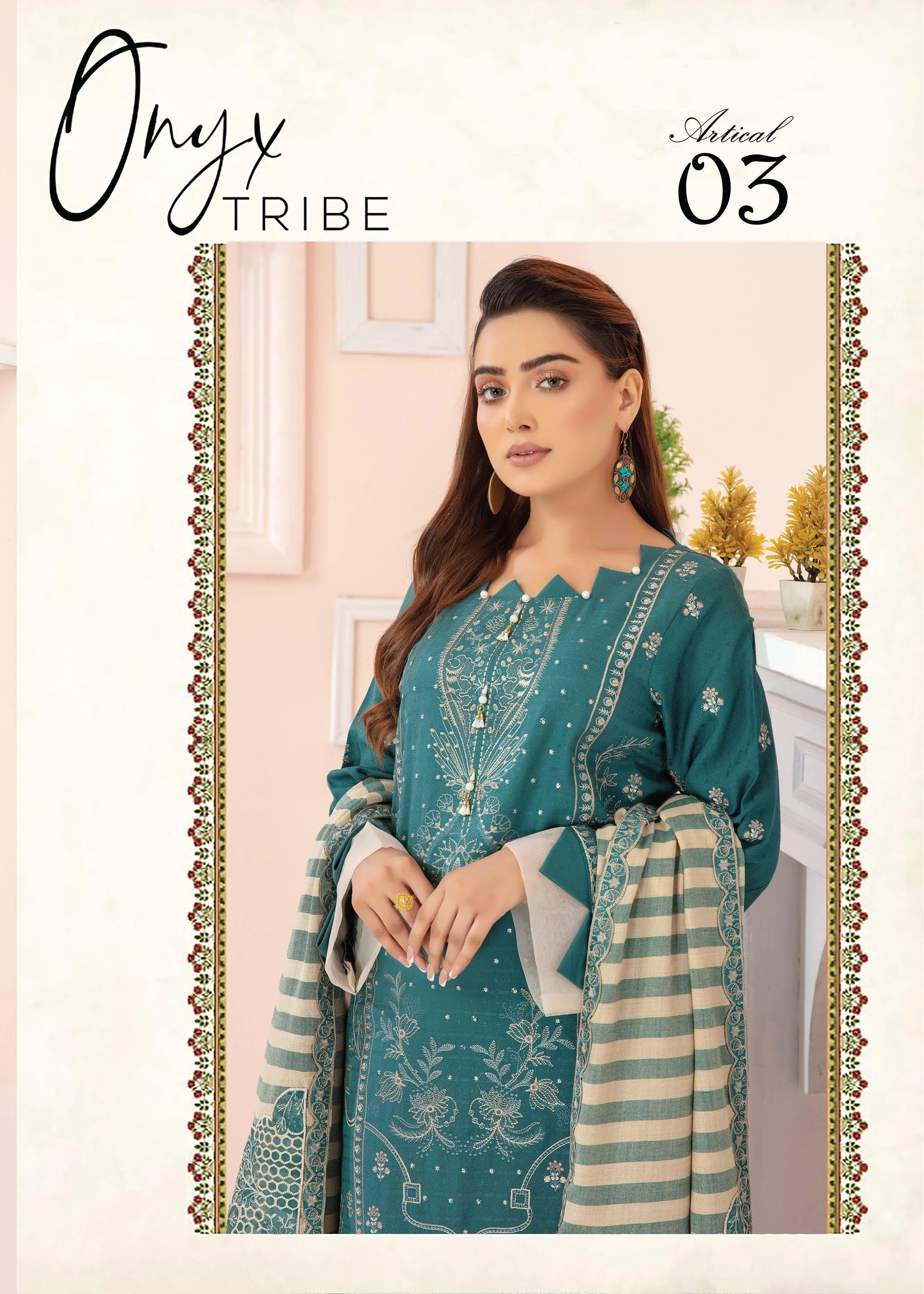 Woman wearing a teal embroidered outfit with matching pants and shawl, standing in a room .