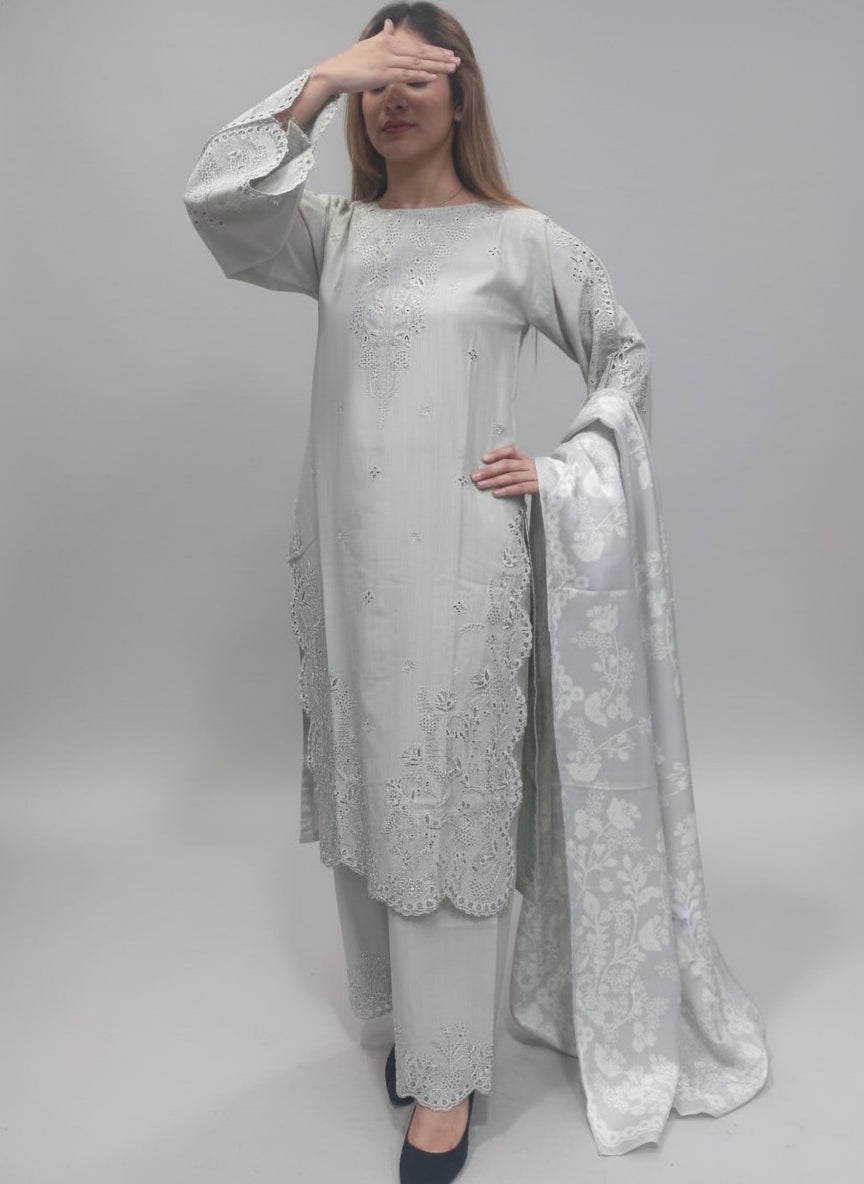 A women wearing a white embroidered outfit against a green background