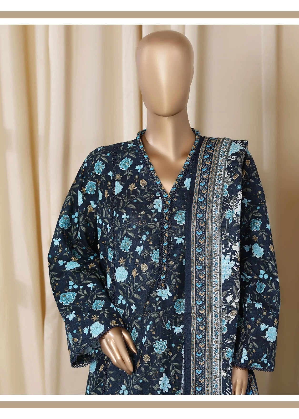 Mannequin wearing a dark floral dress with a chair in the background, labeled 'the Colours of New Season'.