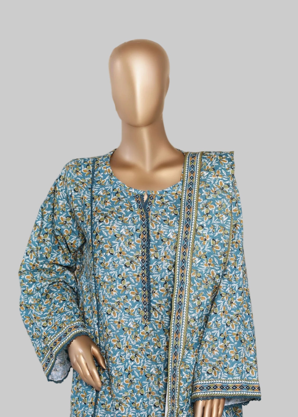 Mannequin wearing a blue floral dress with a decorative chair in the background