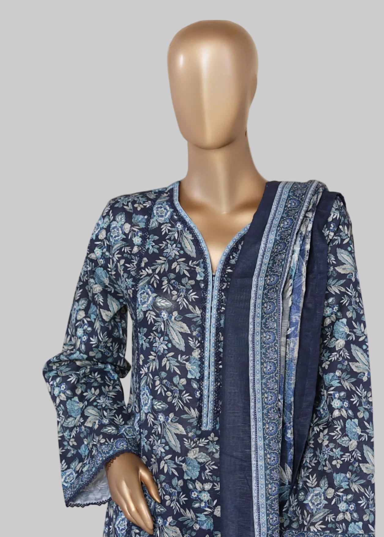 Mannequin wearing a blue floral dress with 'Elegance' text on a beige curtain background