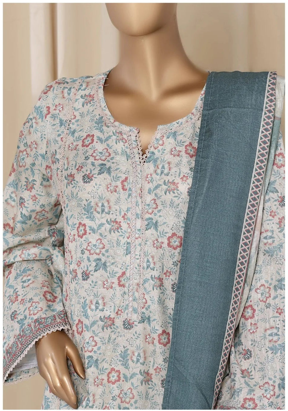 Floral dress with a blue dupatta on a mannequin against a beige curtain background