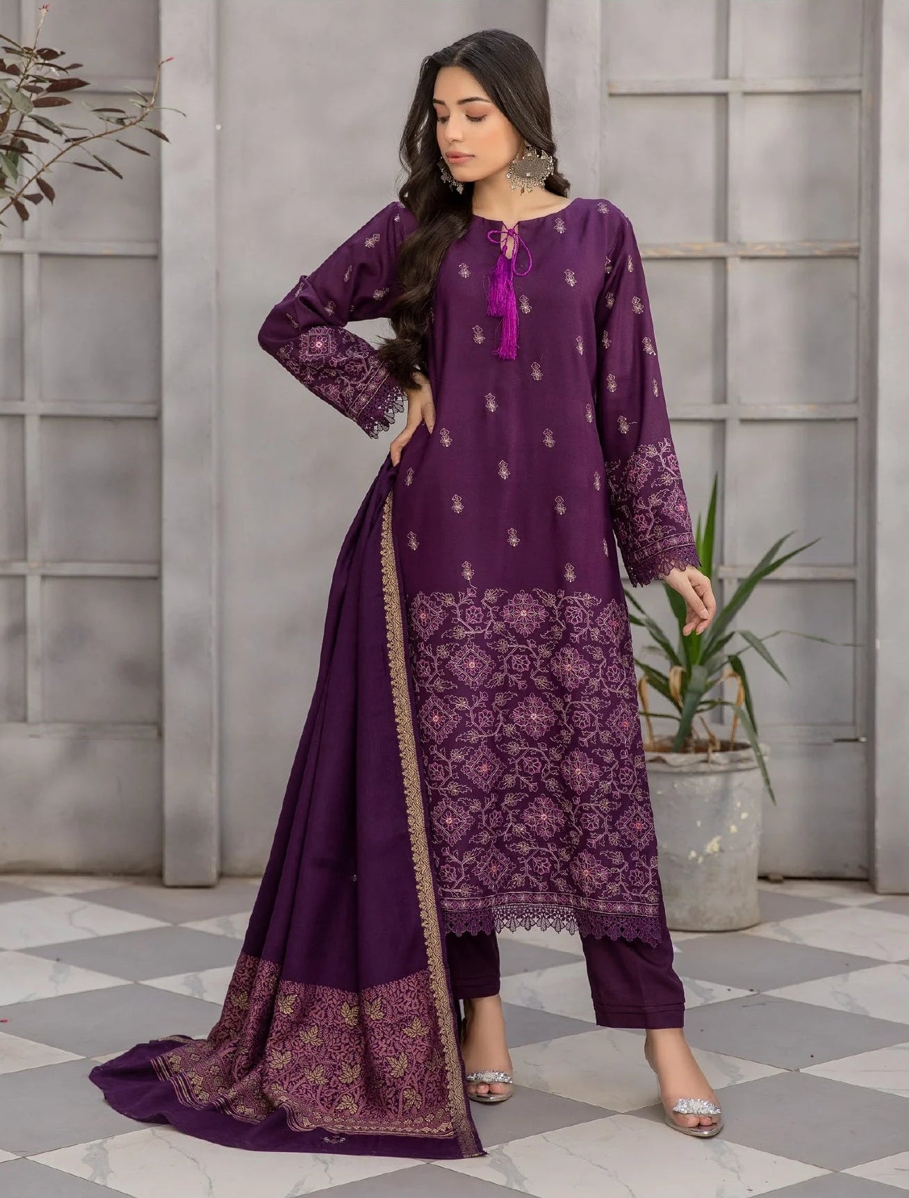 Woman wearing a purple embroidered outfit with a close-up of the fabric, set against a neutral background.