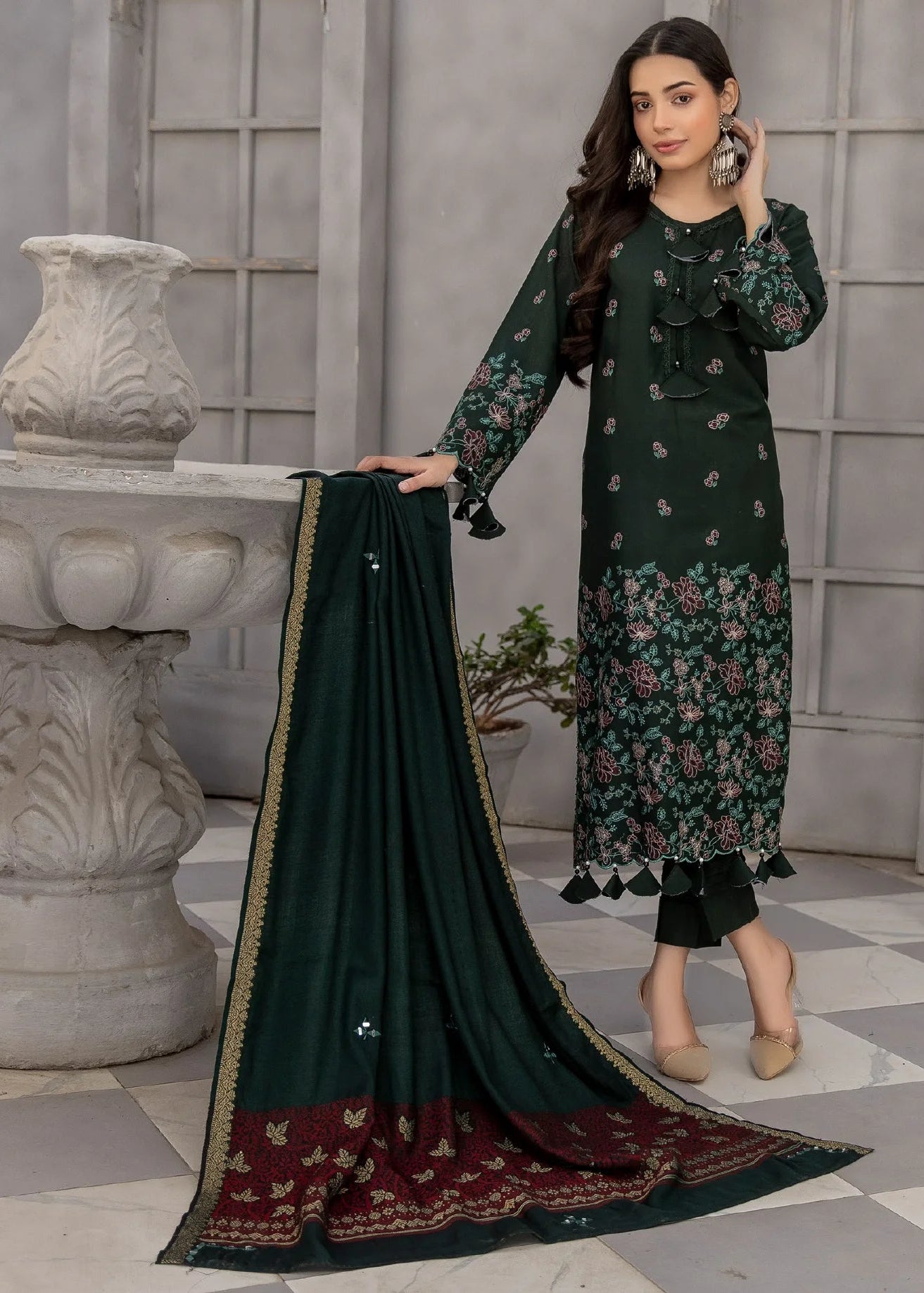 Woman holding a green dupatta with floral patterns in an indoor setting.