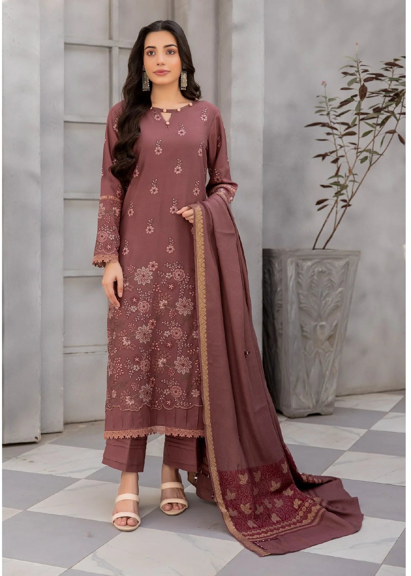 Woman wearing a maroon traditional outfit with a matching dupatta in an indoor setting.
