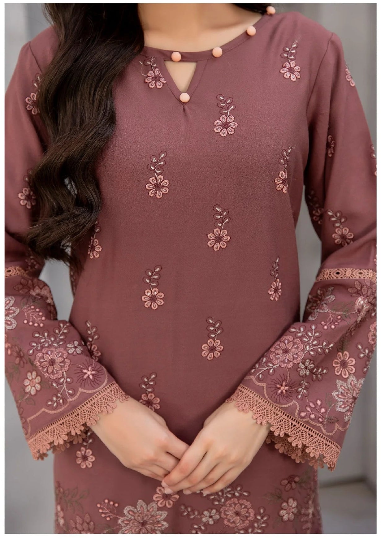 Woman wearing a mauve embroidered outfit with a close-up of the garment.