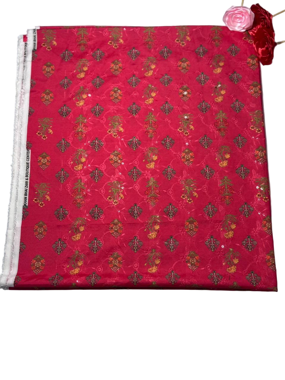 Red fabric with gold floral pattern on a white background