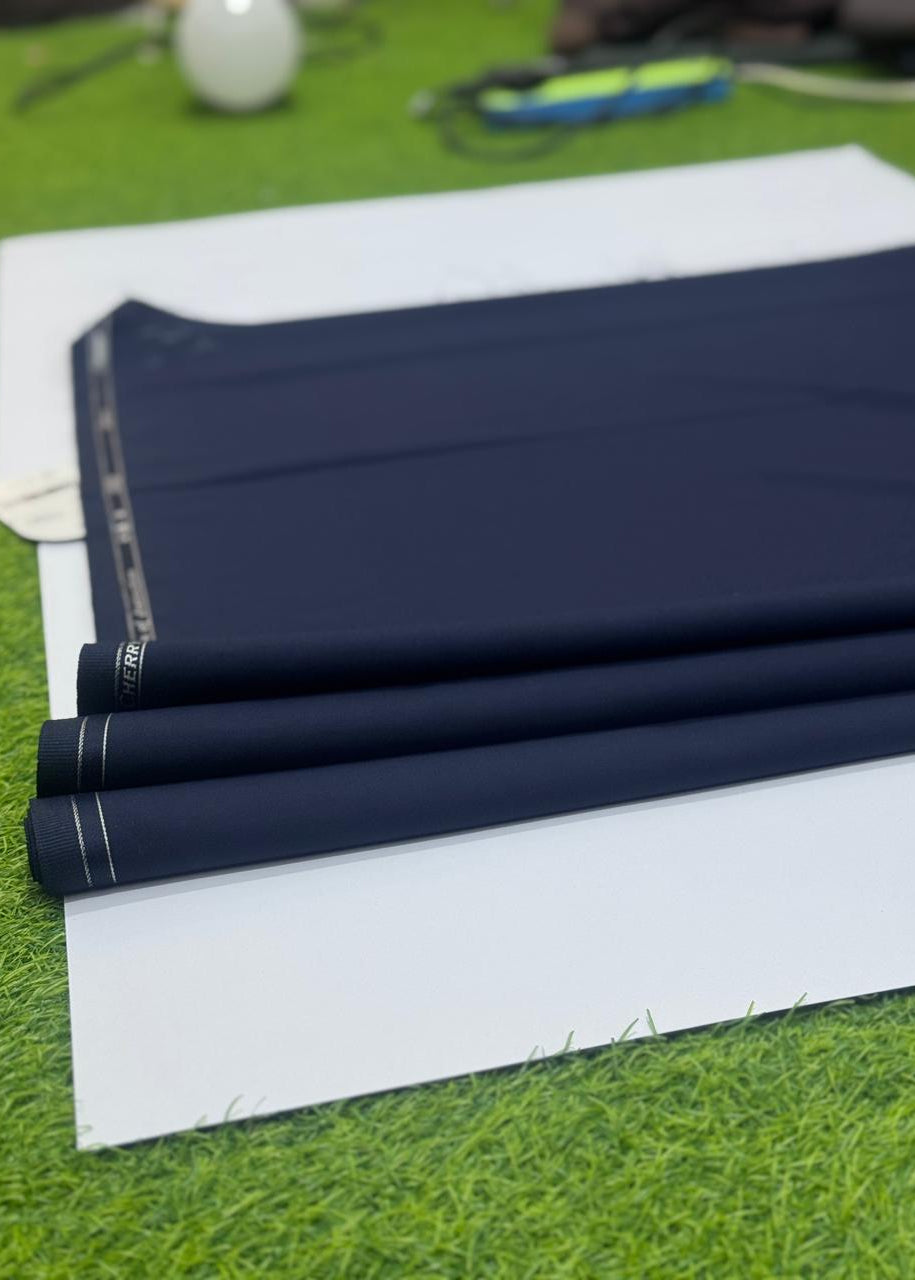 Roll of dark blue fabric on a white sheet with a blurred background