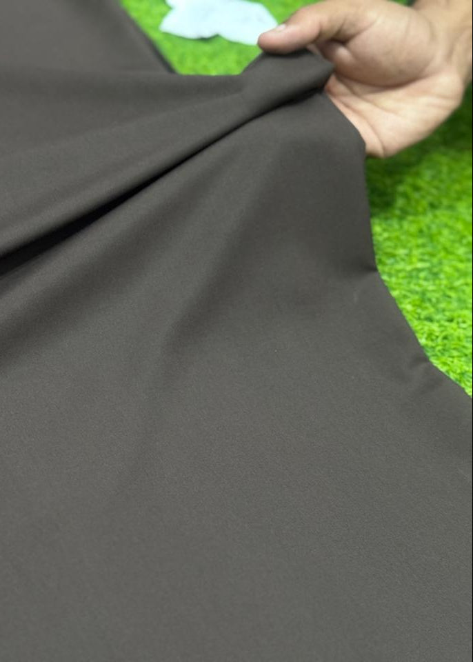 Gray fabric held by a hand with a grass background