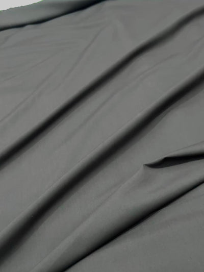 Dark gray fabric with folds on a plain background