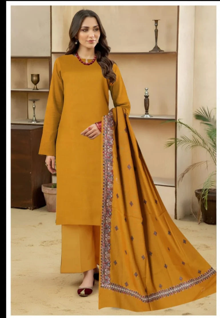 Woman wearing a mustard yellow outfit with a matching dupatta in an indoor setting.