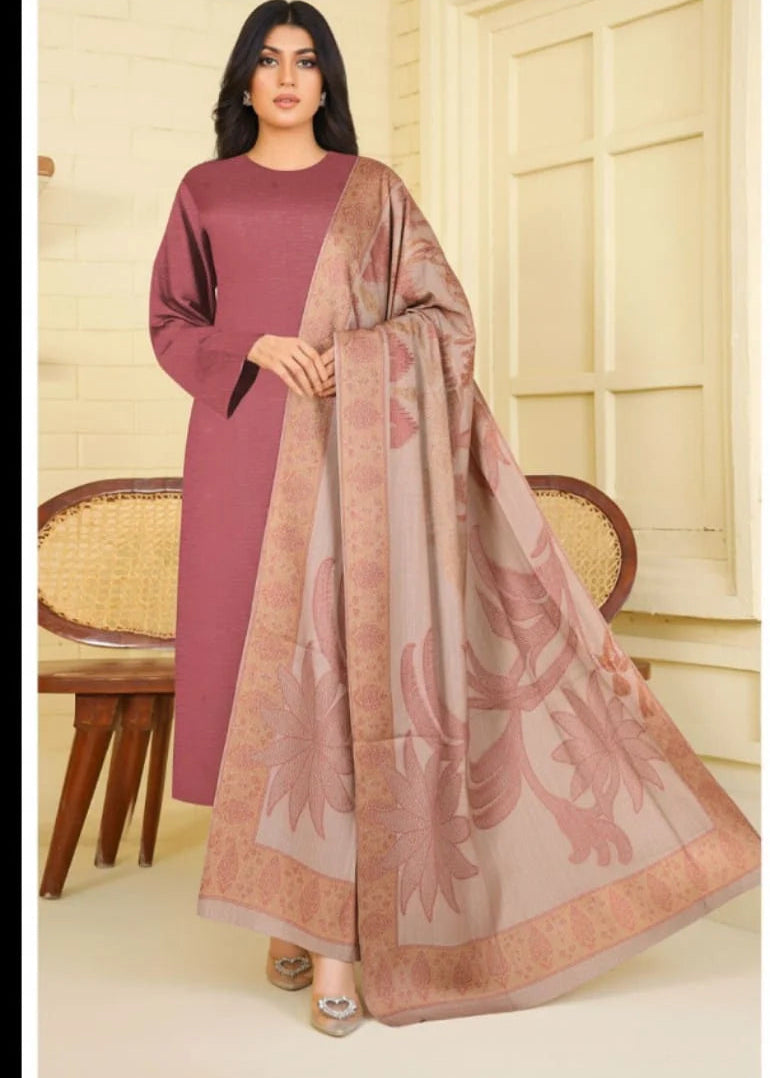 Woman wearing a pink traditional outfit with a matching dupatta in a room.