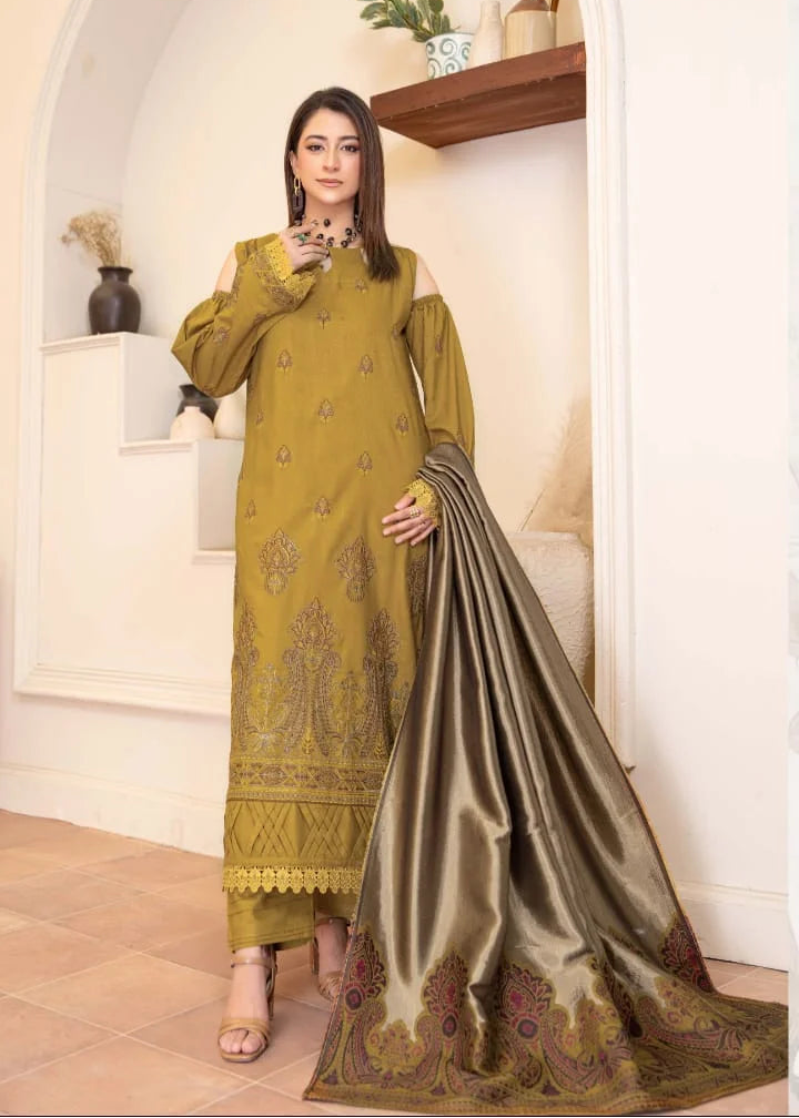 Woman wearing a green embroidered saree with a matching blouse, standing in a well-lit room.