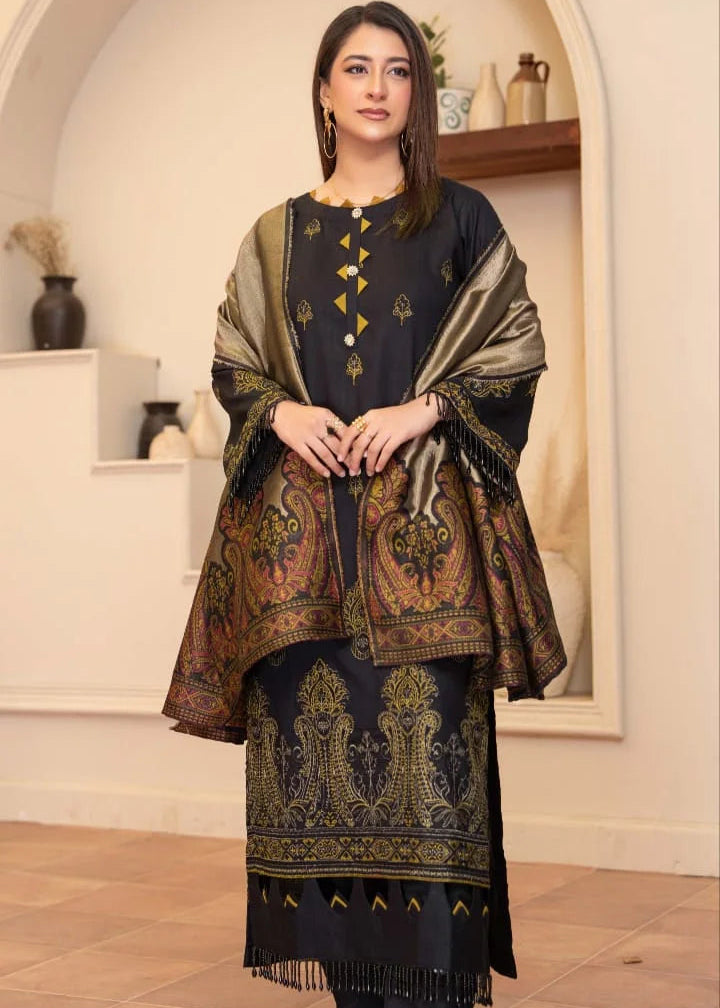 Woman wearing a black and gold traditional outfit with a patterned shawl indoors.