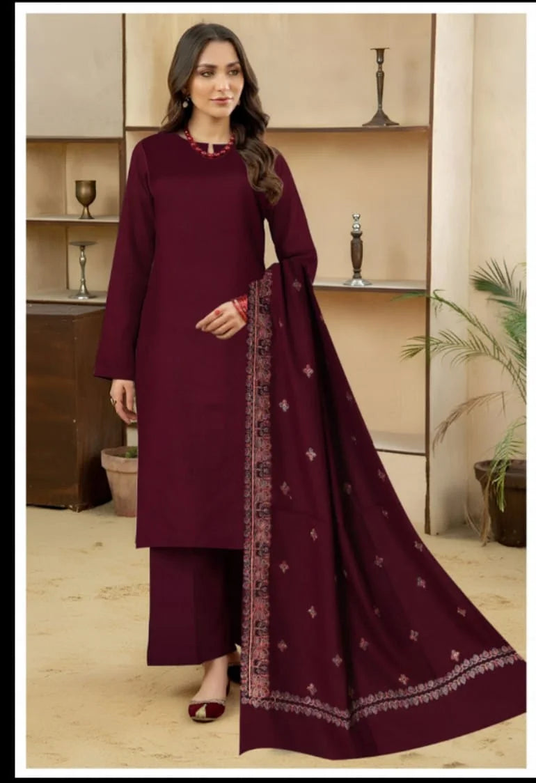 Woman wearing a maroon traditional outfit with a matching dupatta in a well-lit room.