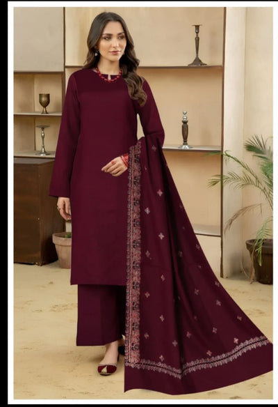 Woman wearing a maroon traditional outfit with a matching dupatta in a well-lit room.