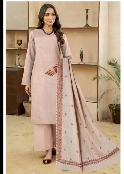 Woman wearing a light pink traditional outfit with a matching dupatta in a room setting.
