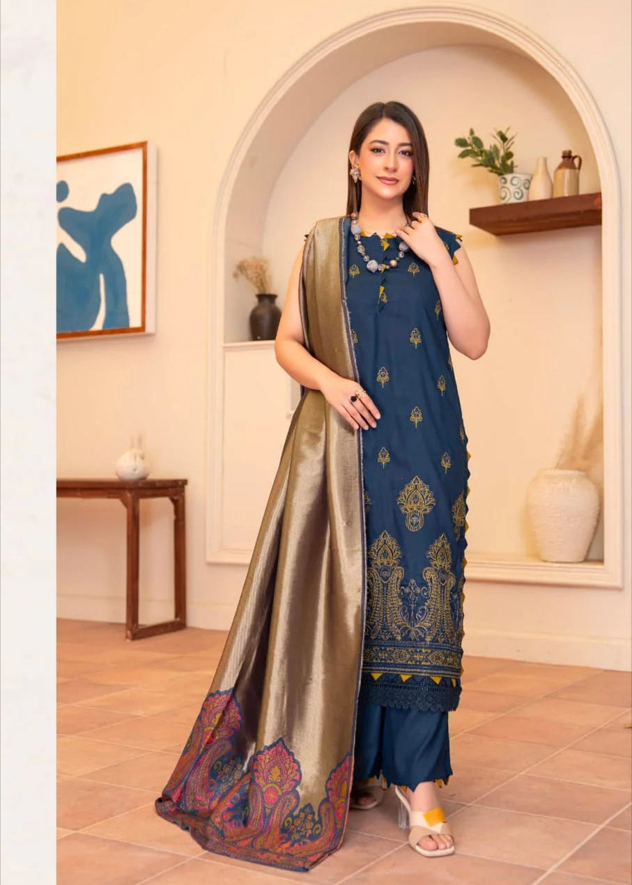 Woman in a blue and gold traditional outfit standing in a decorative room.