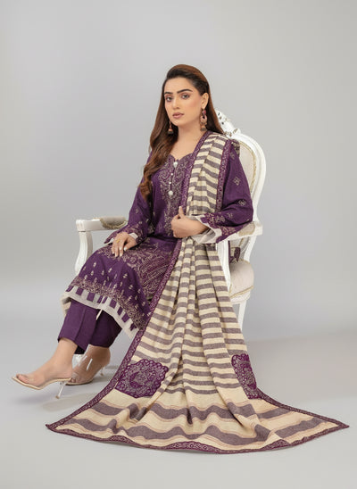 Woman in a purple and beige traditional outfit sitting on a white chair with a fireplace in the background.