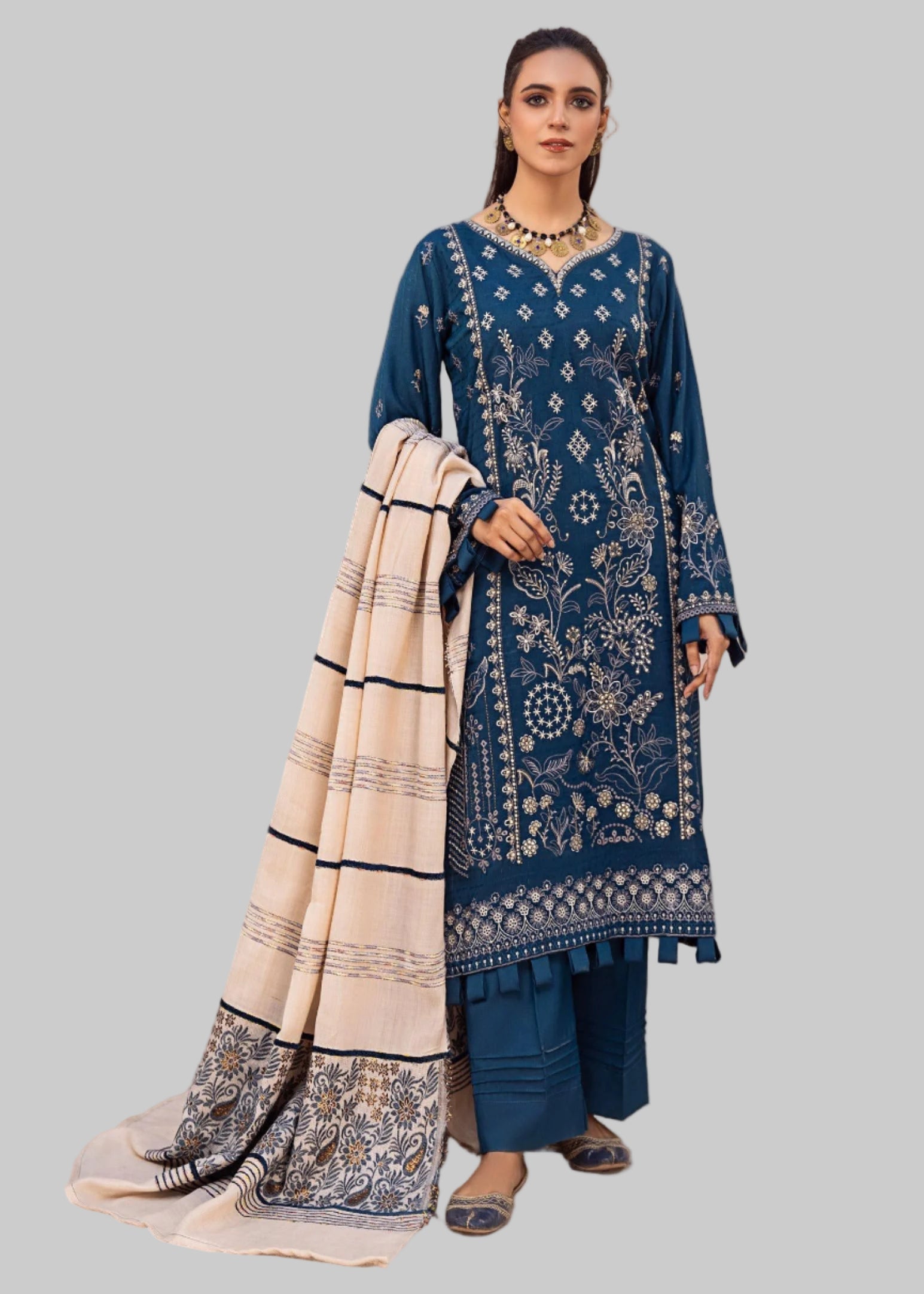 Woman modeling a blue and white traditional outfit in a room .