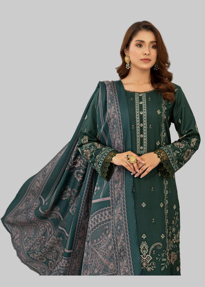 Woman in a green traditional outfit standing next to a table with a red tablecloth and floral arrangement.