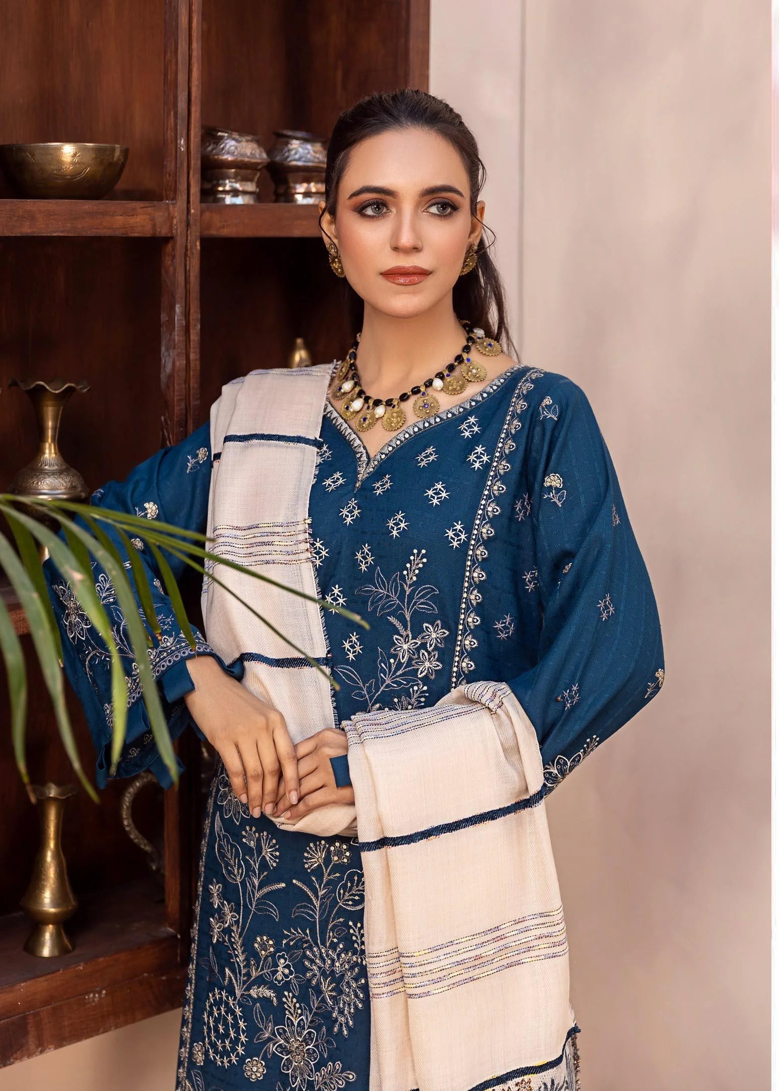 Woman wearing a blue and white traditional outfit with a close-up of the fabric.