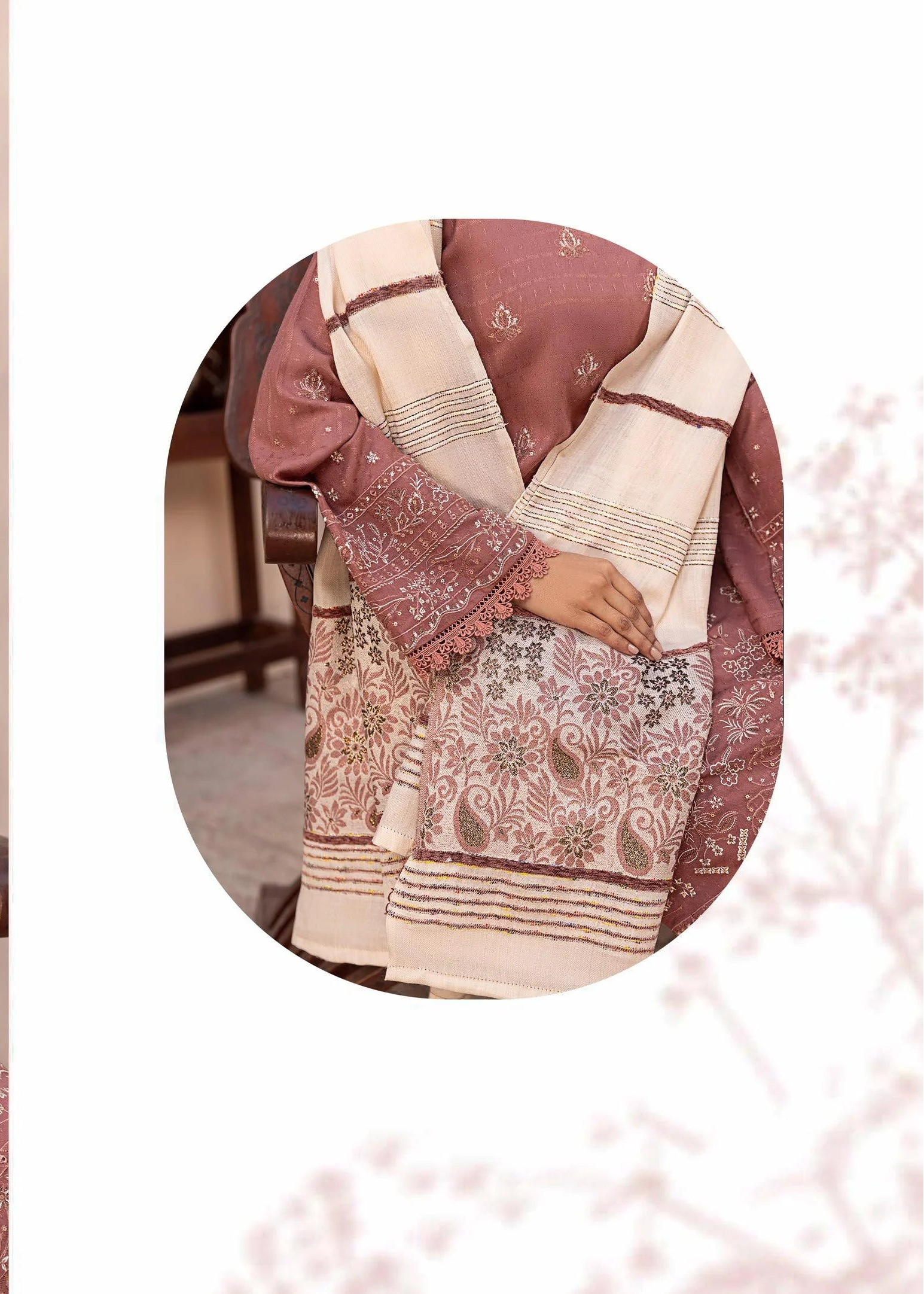 Woman wearing a traditional outfit with a floral pattern, sitting on a chair.