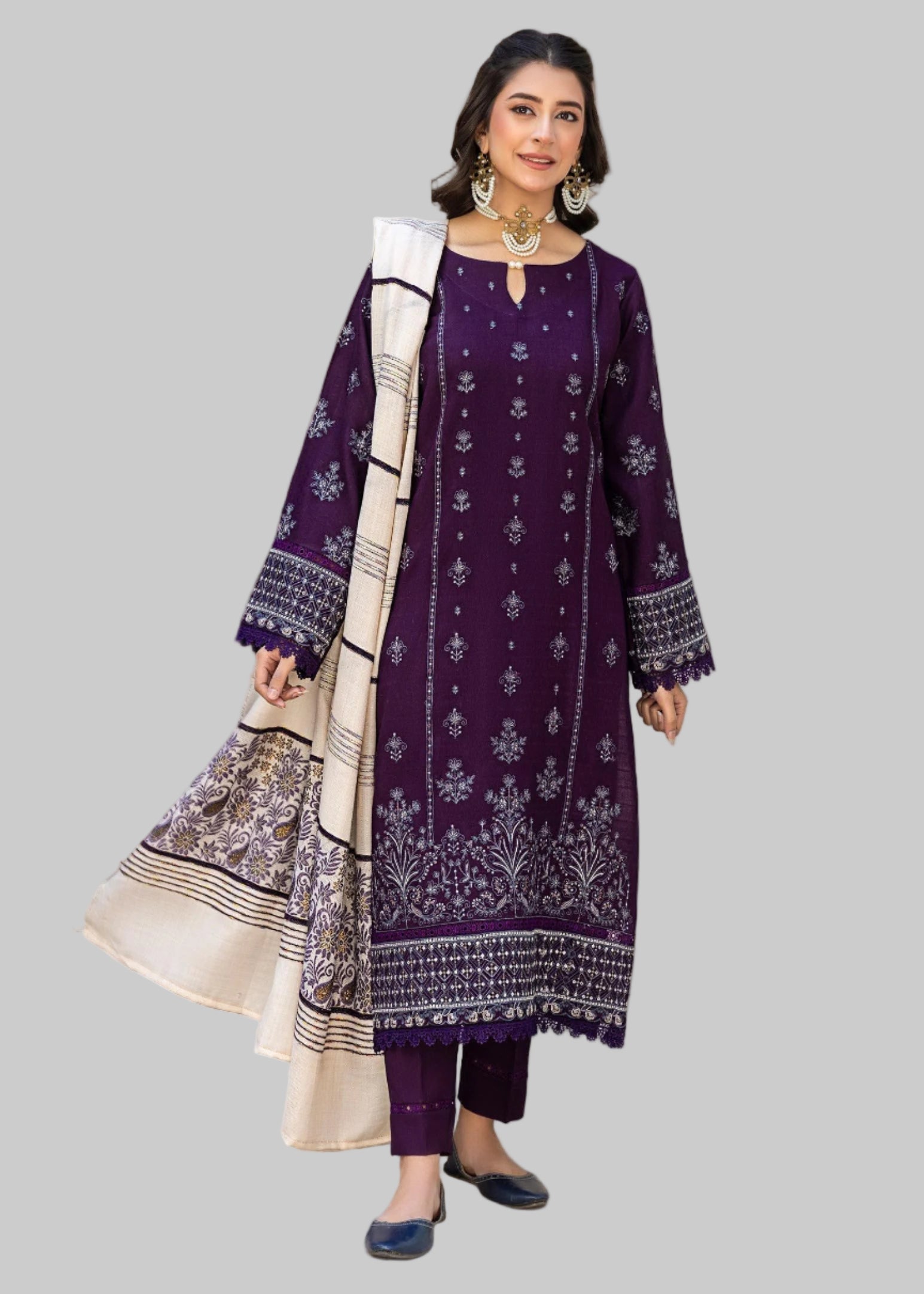 Woman wearing a purple traditional outfit with white patterns in an indoor setting.