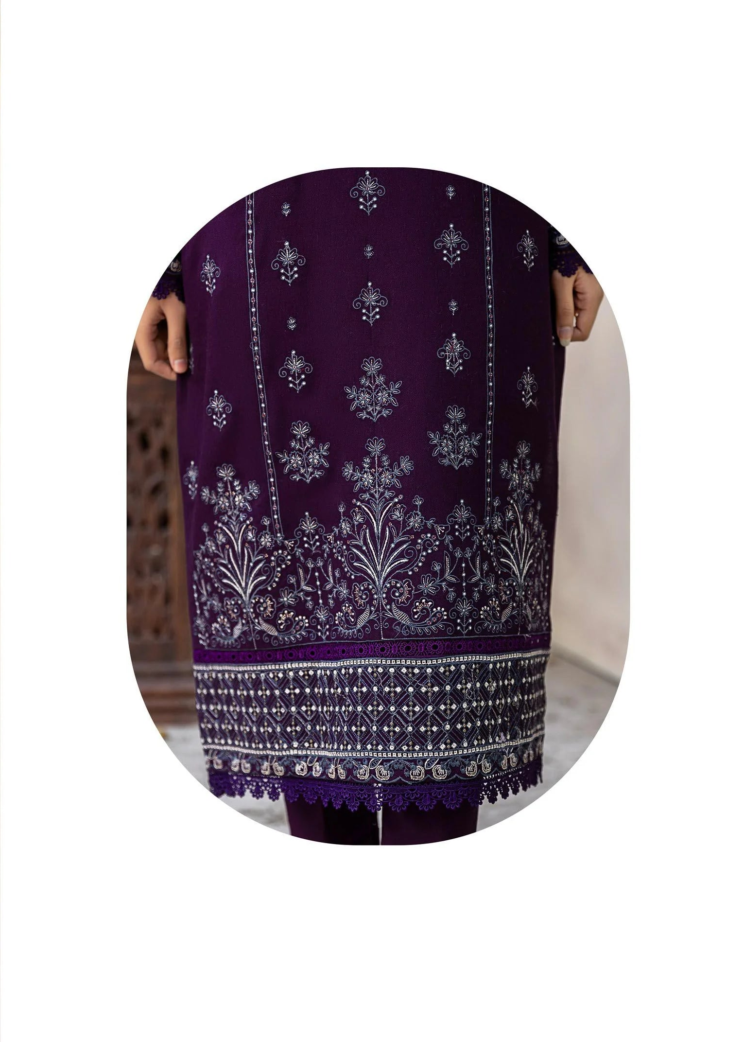 Woman wearing a purple and white traditional outfit with a matching shawl, set against a neutral background.