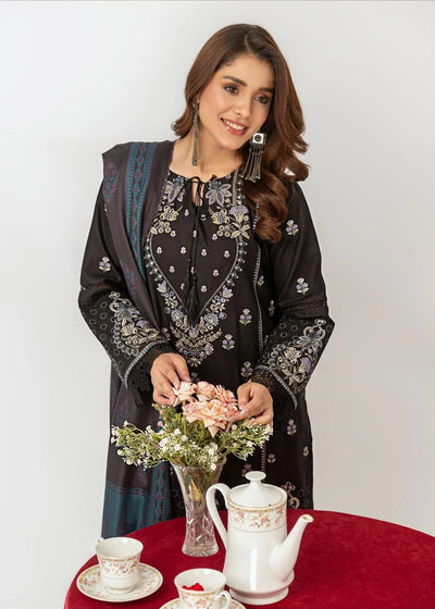 Woman in black and blue traditional outfit with a framed photo of herself at a tea party.