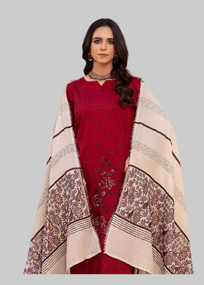 Woman in a red traditional outfit with a patterned shawl standing in a decorated room.