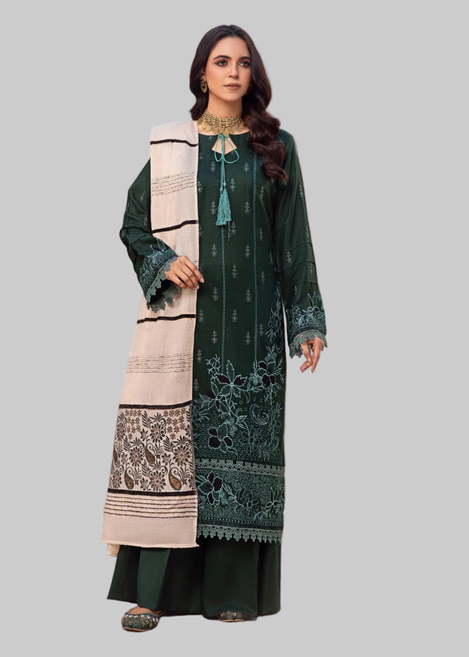 Woman modeling a traditional outfit with a green and beige dress in a Studio Room.